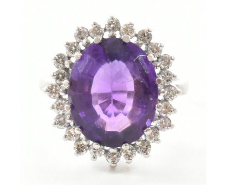 A hallmarked 18ct white gold amethyst and diamond cocktail ring. The ring being set with a richly coloured oval cut amethyst 