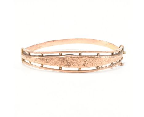 An antique hallmarked 9ct rose gold bangle bracelet. The bangle having etched foliate ivy leaf decoration to the head with fu