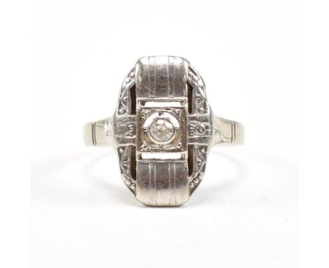 An Art Deco white gold and diamond plaque ring. The antique ring set with a central old cut diamond to pierced and decorated 