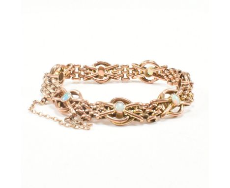 An antique 9ct rose gold and opal chain bracelet. The chain comprised of panther mesh links spaced by fancy link crossover st