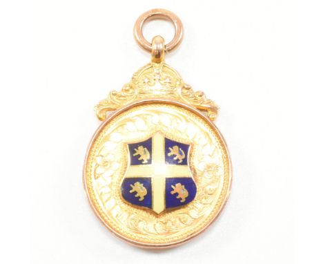 A 1920s hallmarked 9ct gold fob medalet. The medalet having enamelled and blank armorial cartouche surmounted by crown with b