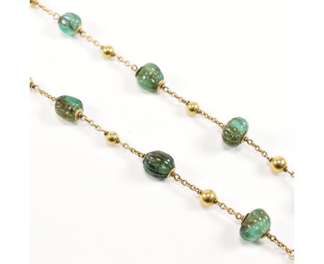 A gold and carved emerald bead necklace. The necklace strung with 15 carved emerald beads having gold bead spacers on a gold 