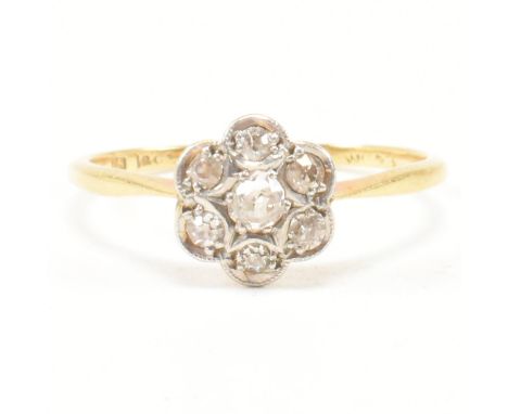 A 1920s 18ct gold and diamond cluster ring. The ring set with seven old cut diamonds in a flower cluster to tapering band. Th