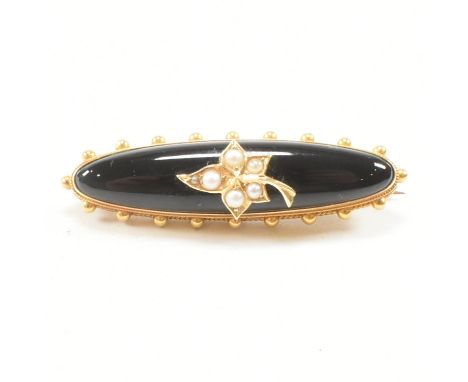 An antique yellow, onyx and seed pearl mourning brooch pin. The brooch of ellipse form having a black stone ground with seed 