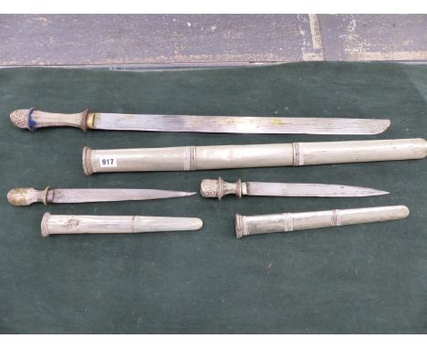 A BURMESE SHORT SWORD WITH WHITE METAL SCABBARD, TOGETHER WITH A PAIR OF SIMILAR SIDE ARMS 