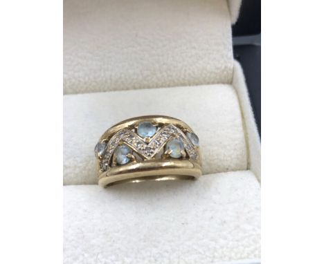 A 9ct HALLMARKED GOLD GEMSET AND DIAMOND RING. THE SETTING WITH FIVE CLAW SET LIGHT BLUE GEMS AND A ZIGZAG SETTING OF DIAMOND