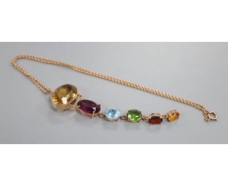 A yellow metal and graduated oval multi gem set pendant, on a yellow metal chain, including citrine, amethyst and peridot, pe