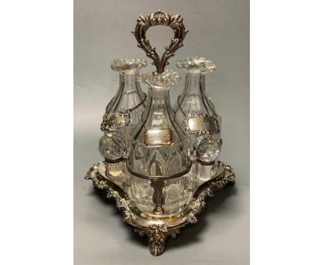 A set of three early 19th century glass decanters, now with facetted stoppers, and a silver label, on later silver plated dec