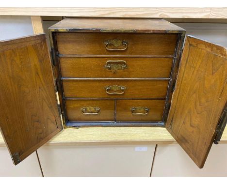 A Korean elm brass mounted table top cabinetCONDITION: Large splits to both doors, right hand door as you are facing it is mi