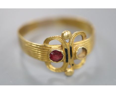 An antique reeded yellow metal and two stone set scroll ring, (stone missing and other stone chipped), size R/S, gross 1.6 gr