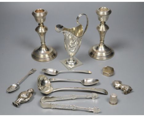 A quantity of small silver to include a pair of candlesticks, sauce ladle, cream jug etc and a silver plated rattle, weighabl