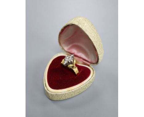 An 18ct and diamond cluster dress ring, in a raised setting, size Q/R, gross 5.9 grams.CONDITION: Slight wear to the settings