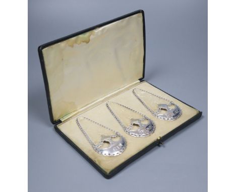 A cased set of three silver wine labels by Daniel &amp; John Welby, London, 1911, 5cm, 29 grams, of crescent with urn form, i