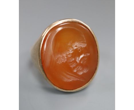A late 19th century yellow metal and oval carnelian intaglio ring, carved with the head of a gentleman to sinister, size R, g