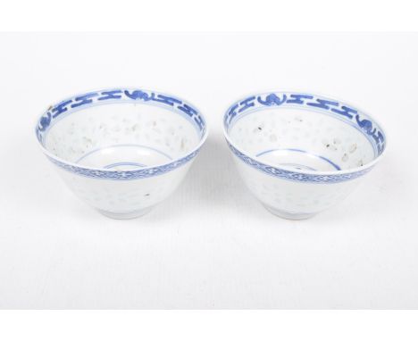 A pair of Chinese blue and white bowls, 19th/20th CenturyEach of 'U' form, with traditional scroll and rugi bat borders and l