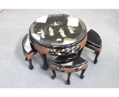 A japanned hardwood circular nest of tablesThe central table with a circular glass top enclosing a panel applied with geisha 