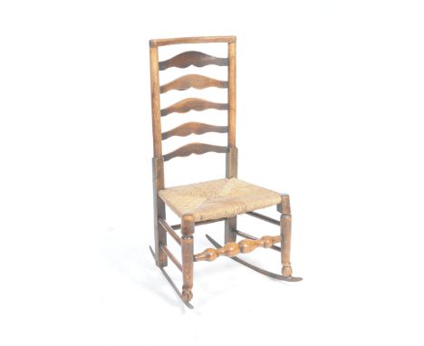 An 18th Century ash ladder back rush seat rocking chairWith a five rung back above an envelope rush seat supported on taperin