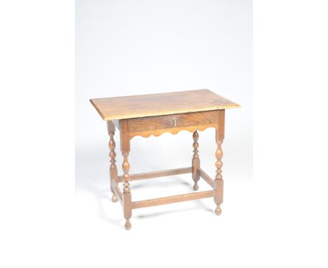 An 18th century oak side tableWith a moulded three plank top above a single frieze drawer raised on bobbin turned supports wi