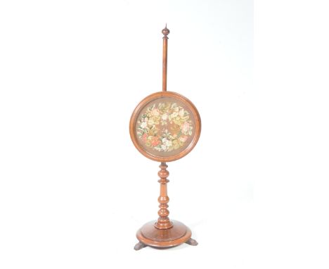 A mid 19th Century mahogany pole screenWith a spherical finial and a circular glazed floral needlework panel raised on a ring