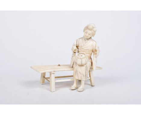 A Japanese carved ivory Okimono, Meiji periodThe sectional figure modelled as a bijin with basket, seated on a bamboo bench, 