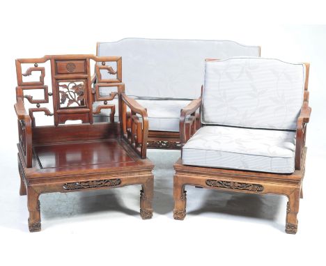 A Chinese Huanghuali hardwood three piece lounge suiteThe chairs with a central shou symbol above an openwork panel carved wi