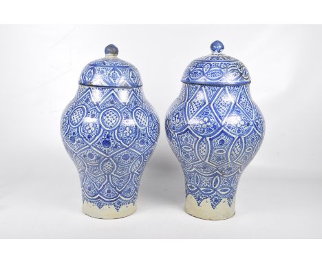 A pair of Turkish Iznik style vasesEach of shouldered ovoid form surmounted by a domed cover and pointed finial, with all ove