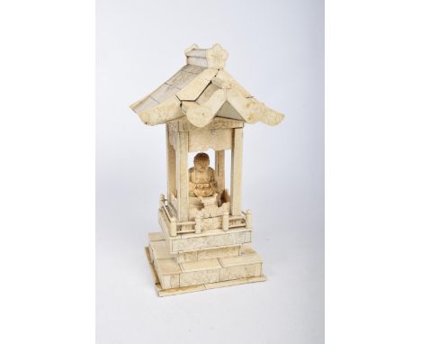 A Chinese carved ivory and bone travelling shrine, early 20th Century Modelled as a roofed shrine with carved panels, enclosi