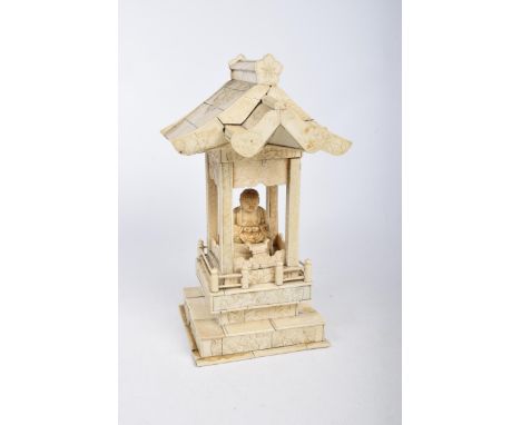 A Chinese carved ivory and bone travelling shrine, early 20th Century Modelled as a roofed shrine with carved panels, enclosi