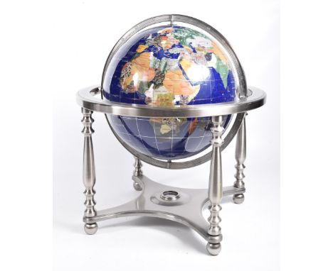 A mother of pearl and gemstone world globeMounted upon a brushed metal frame, the lower cross stretcher inset with a compass,