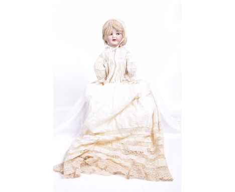 A German bisque headed dollWith blonde wig, blue eyes with sideways movement, open mouth with tongue, impressed marks K*R Sim