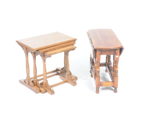 A nest of three oak tables and an oak drop leaf occasional tableThe nest of tables supported on ring turned tapering uprights