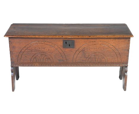 A 17th century oak six plank coffer of small proportions Having a rectangular moulded plank top enclosing a fitted candle box
