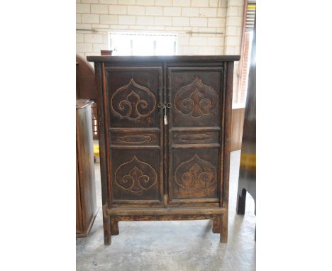 A Chinese Ming Huanghuali style cabinetWith a substantial slab top over two panelled doors, each embellished with ruyi mouldi