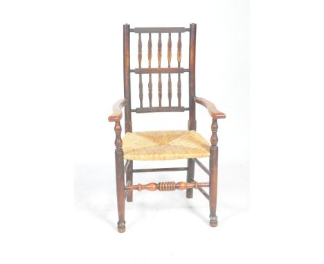 An 18th/19th century beech and ash Lancashire elbow chairThe back with two rows of five spindles above curved outswept arms a