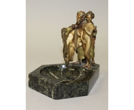 A GOOD AUSTRIAN PAINTED COLD CAST GROUP AS AN ASHTRAY, the Arab man holding a cloak around a young lady which covers her nudi