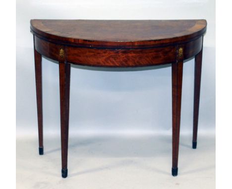 A GEORGE III MAHOGANY HALF MOON CARD TABLE with crossbanded folding top, green baize interior, oval patria inlay to the tops 