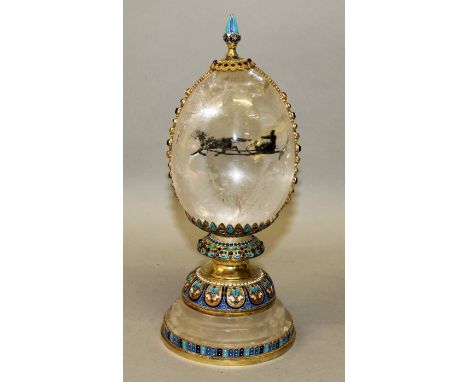 A SUPERB RUSSIAN ROCK CRYSTAL SILVER AND ENAMEL EGG, the interior with Troika and supported on a circular base.  9.75ins high