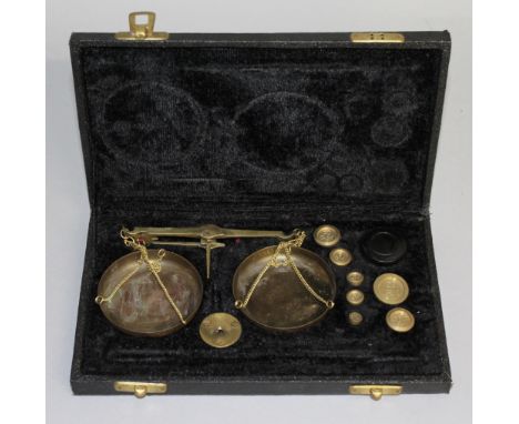 A SET OF GOLD SCALES AND WEIGHTS in a fitted case.