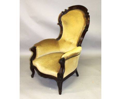 A VICTORIAN ROSEWOOD FRAMED SPOON BACK ARMCHAIR with carved show wood frame.