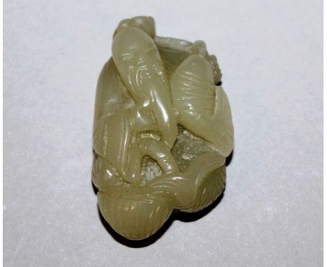 A 19TH/20TH CENTURY CHINESE CELADON JADE-LIKE PENDANT, carved in the form of a fisherman holding a carp, 2.25in high.