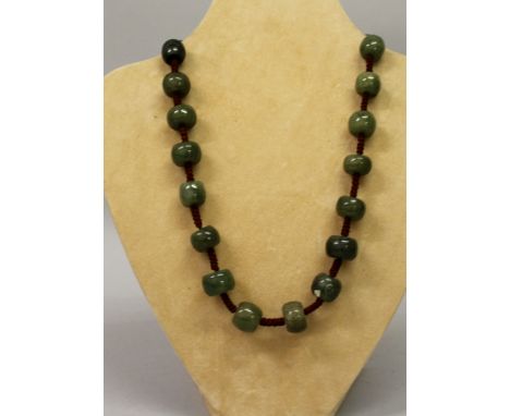 A DARK GREEN JADE NECKLACE.