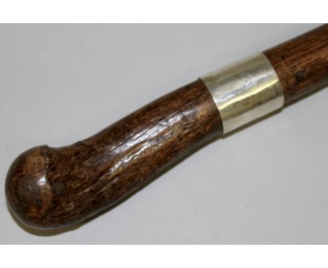 A WOODEN STICK SILVER BAND KUBAND.  37ins long.