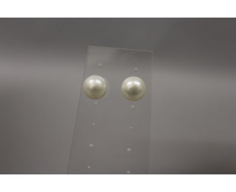 A pair of freshwater pearl button earrings, each fitted with 9ct gold fittings.