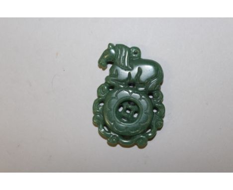 A GREEN JADE PIERCED PENDANT.