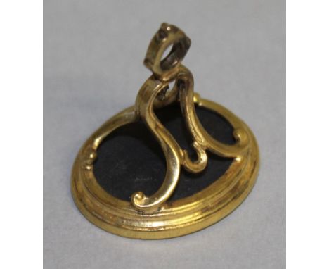 A GEORGIAN GILT METAL MOUNTED FOB SEAL, the oval basalt intaglio incised with a male portrait profile, with bell shaped scrol
