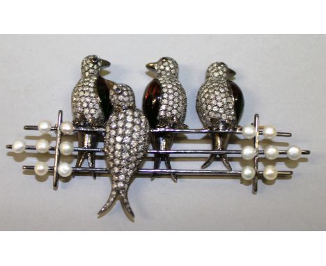 AN UNUSUAL DIAMOND, ENAMEL AND PEARL BROOCH set as four birds on a fence.