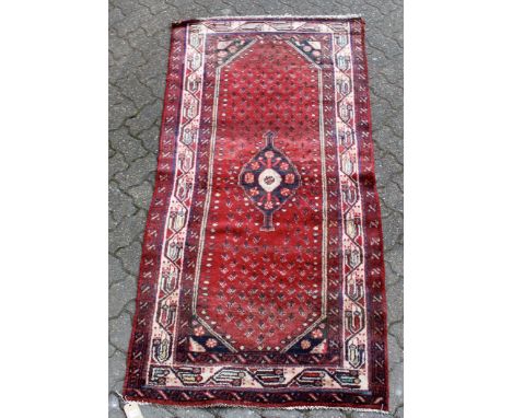 A small Hamadan rug, red ground with mirror design decoration. 6ft 4ins x 3ft 3ins.