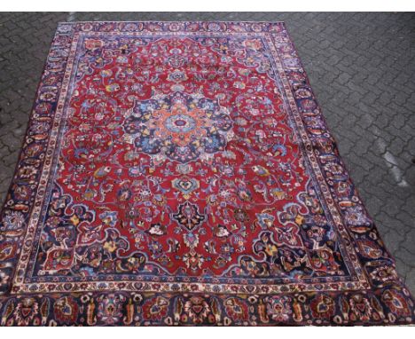 A Kashan carpet, claret ground with stylized floral decoration. 11ft 6ins x 8ft 5ins.