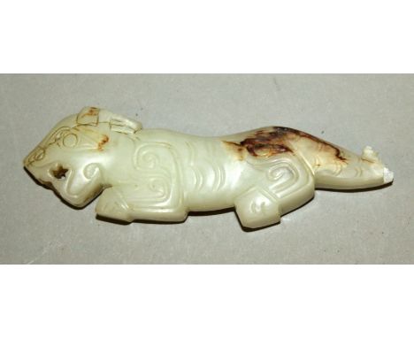 A CHINESE PALE CELADON JADE CARVING, of archaic style and in the form of a mythical animal, the stone with white and russet i