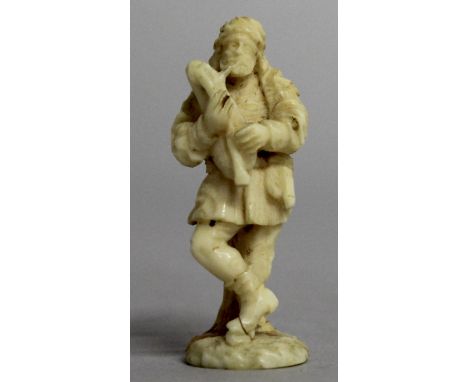 A CARVED IVORY DESK SEAL, with plain oval base, the grip carved as a figure playing an instrument.  4.8cms long.